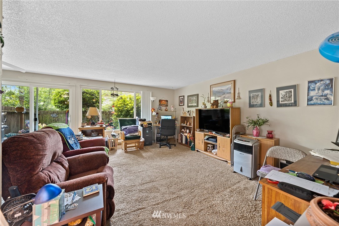 980 Edmonds Avenue Northeast Renton, WA 98056 - Photo 11 of 28 a living room with furniture a large window and a flat screen tv