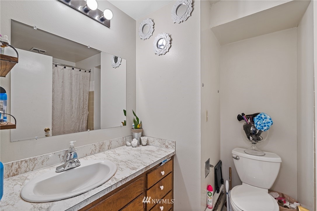 980 Edmonds Avenue Northeast Renton, WA 98056 - Photo 18 of 28 a bathroom with a granite countertop toilet sink and mirror