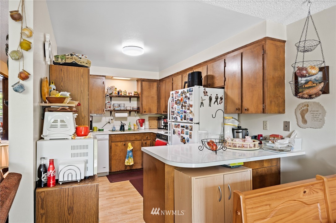 980 Edmonds Avenue Northeast Renton, WA 98056 - Photo 9 of 28 a kitchen with stainless steel appliances kitchen island granite countertop a sink and cabinets