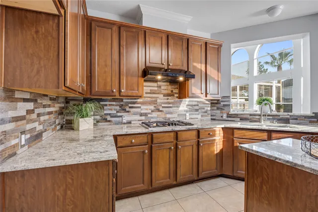 a kitchen with stainless steel appliances granite countertop a sink a stove counter space and cabinets