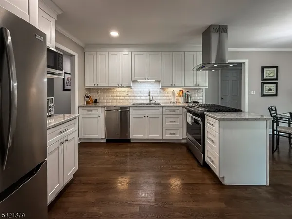 a kitchen with granite countertop a sink stainless steel appliances and cabinets