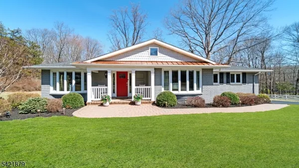 a front view of a house with yard and green space