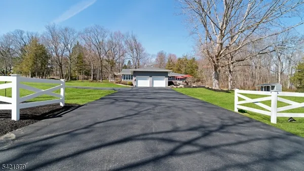 a view of a house with a yard and a large tree