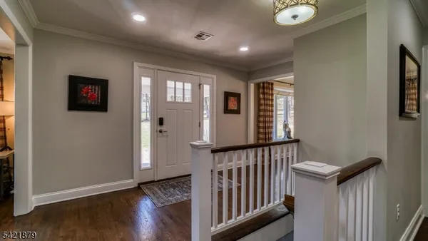 a view of a hallway with wooden floor and stairs