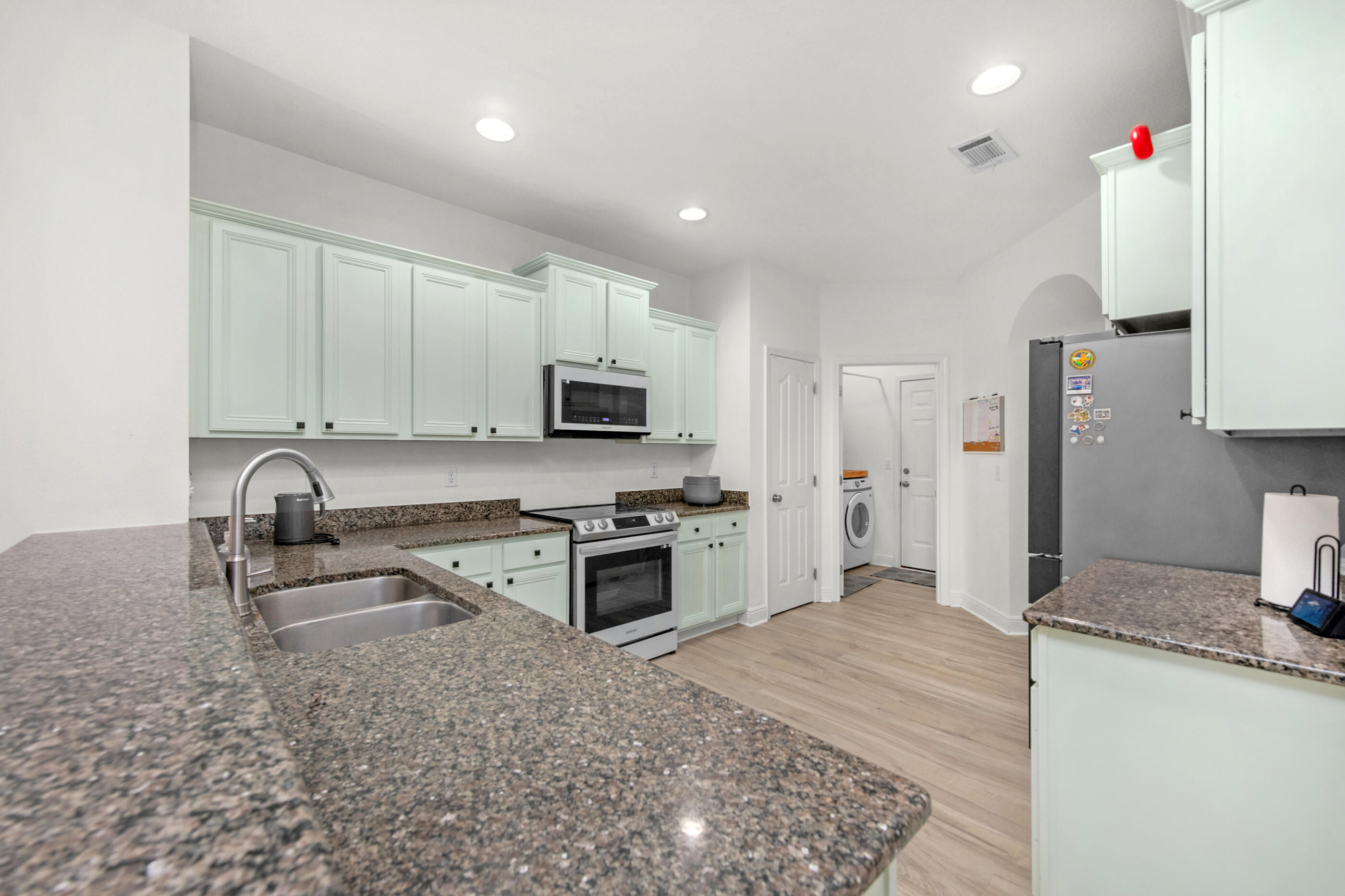653 Red Fern Road Crestview, FL 32536 - Photo 13 of 34 a kitchen with granite countertop a sink stove and refrigerator