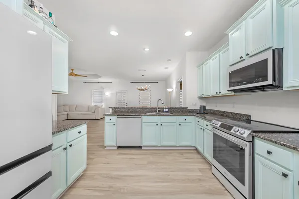 a kitchen with granite countertop cabinets stainless steel appliances and a sink