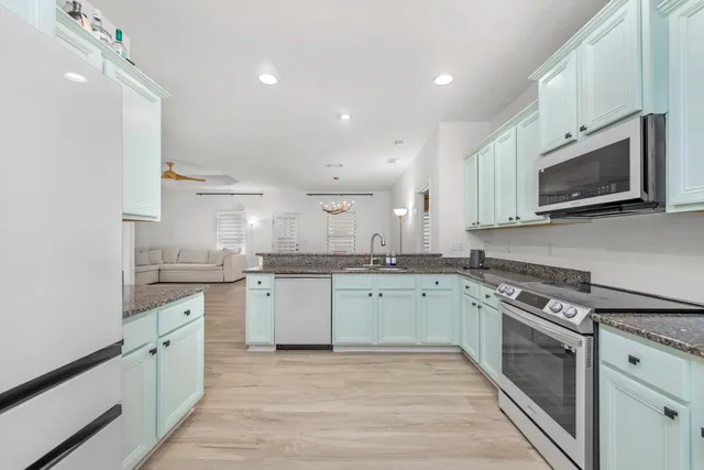 a kitchen with granite countertop cabinets stainless steel appliances and a sink