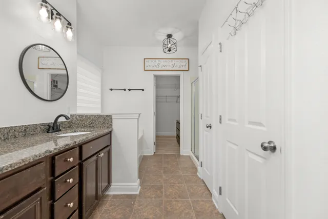 a bathroom with a granite countertop sink and a mirror