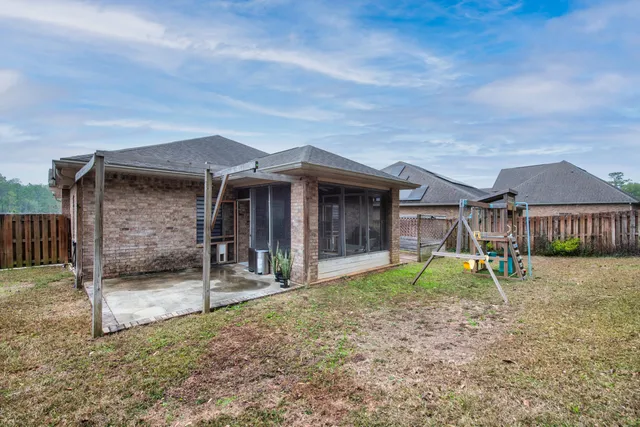 a backyard of a house with barbeque oven table and chairs
