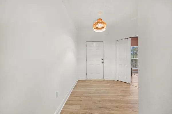 a view of a room with wooden floor and a window