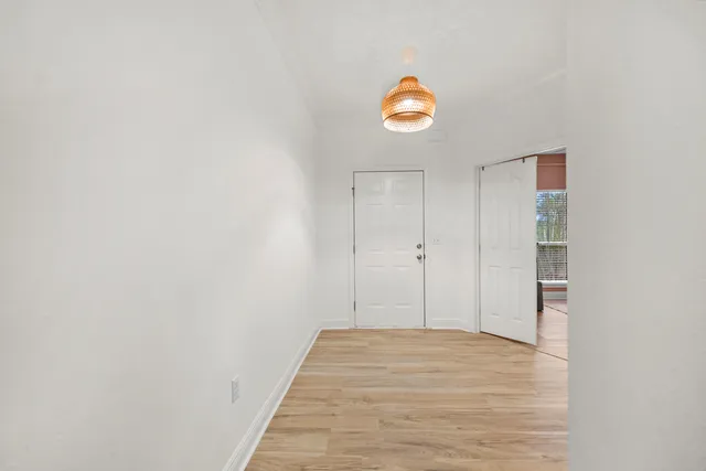 a view of a room with wooden floor and a window