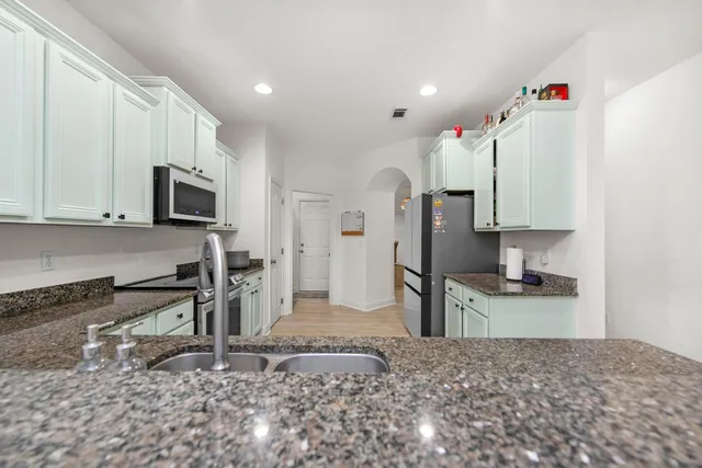 a kitchen with stainless steel appliances granite countertop a sink stove and refrigerator