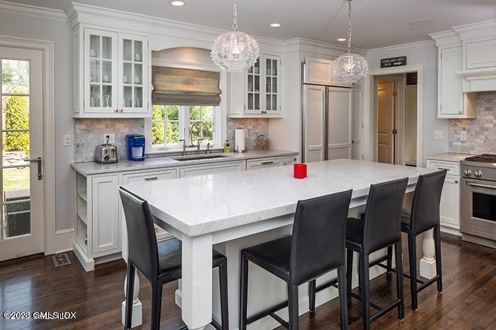 10 Field Road Riverside, CT 06878 - Photo 10 of 18 a kitchen with a dining table chairs stainless steel appliances and windows