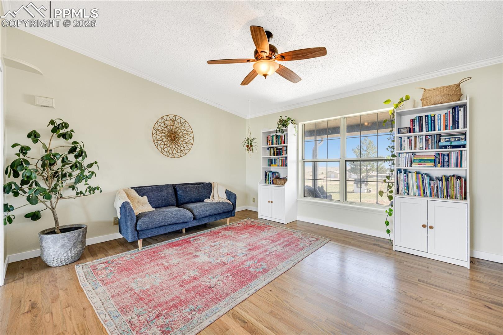 17520 Fremont Fort Road Peyton, CO 80831 - Photo 12 of 42 This spacious living area features hardwood floors and a ceiling fan, enhancing comfort and style