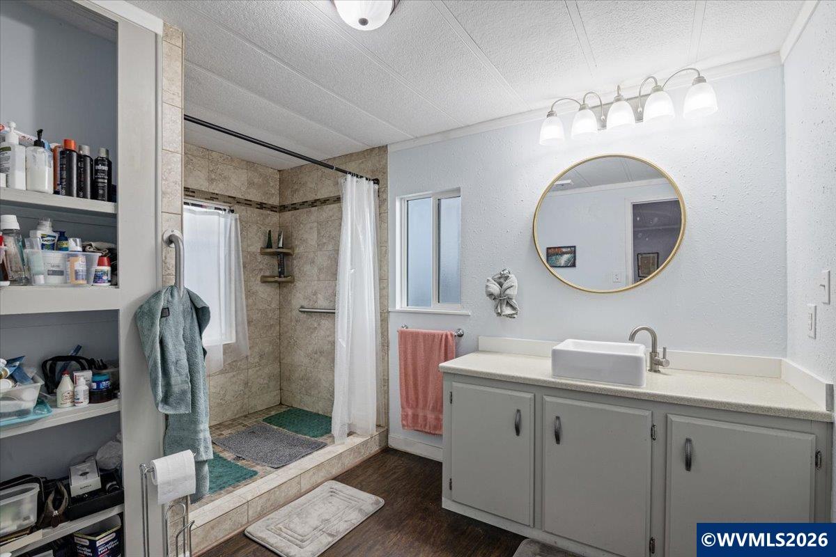 5422 Portland Road Northeast, Unit 123 Salem, OR 97305 - Photo 21 of 23 a bathroom with a sink a mirror and a shower