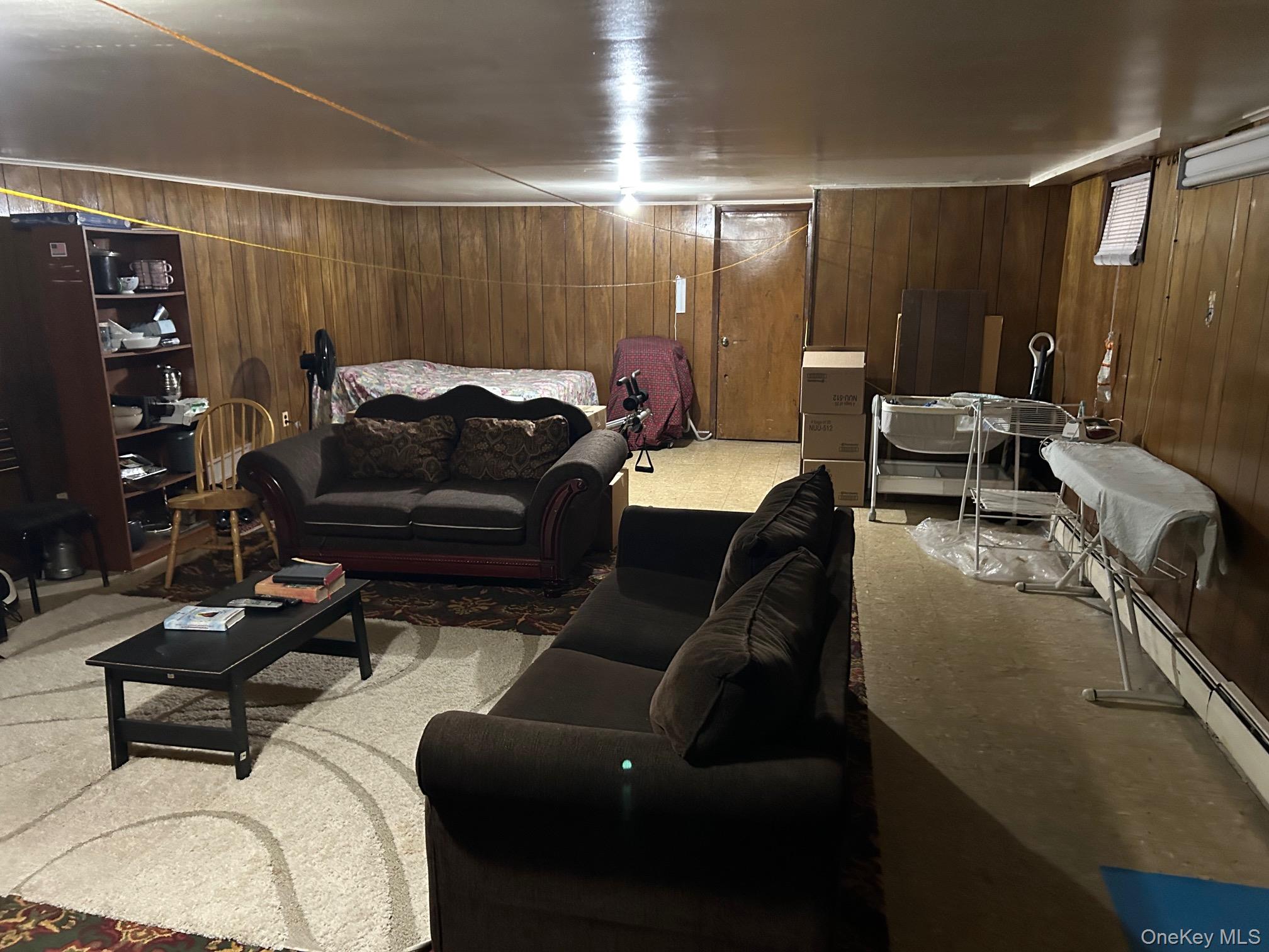 17 Sneden Place West, Unit 17 Spring Valley, NY 10977 - Photo 19 of 29 Living area with wooden walls and a baseboard radiator
