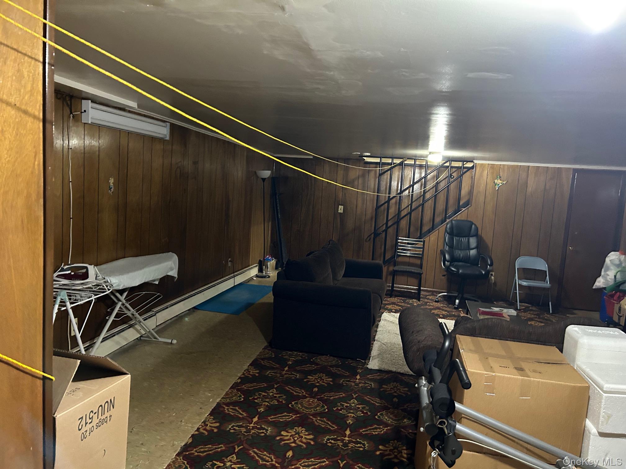 17 Sneden Place West, Unit 17 Spring Valley, NY 10977 - Photo 24 of 29 Finished basement with stairs, baseboard heating, and wood walls