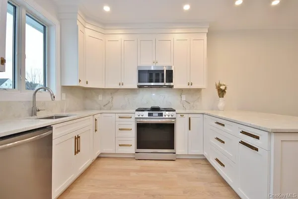 a kitchen with stainless steel appliances granite countertop a stove and a microwave