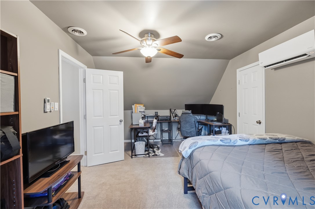 20108 Eugene Drive Sutherland, VA 23885 - Photo 27 of 41 a bedroom with a bed and a flat tv screen on a dresser