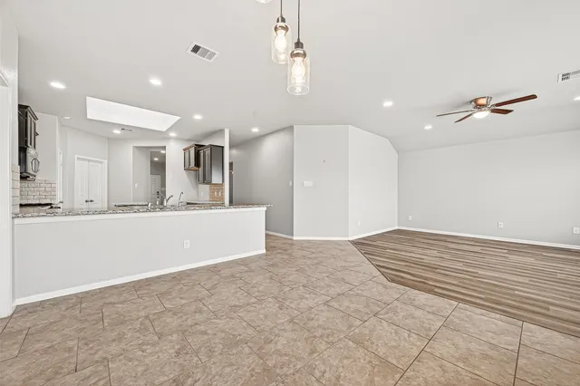 a view of an empty room and kitchen view