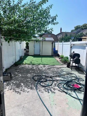 a backyard of a house with barbeque oven and a table and chairs