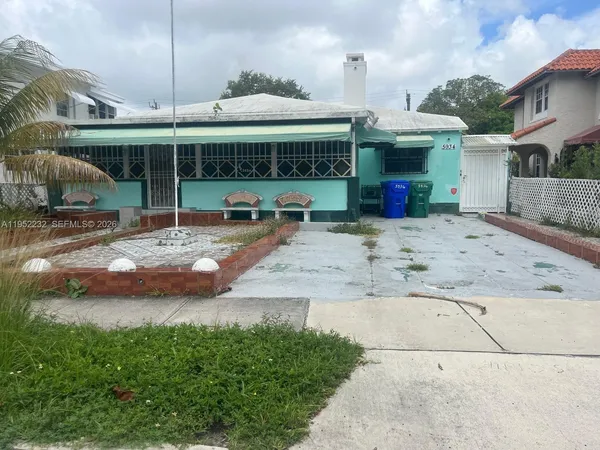 a view of a house with a yard and sitting area