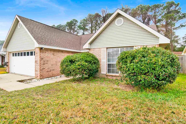 a view of a house with a yard and potted plants