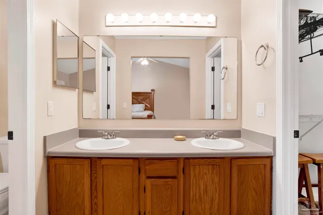 a bathroom with a granite countertop sink a toilet and a mirror