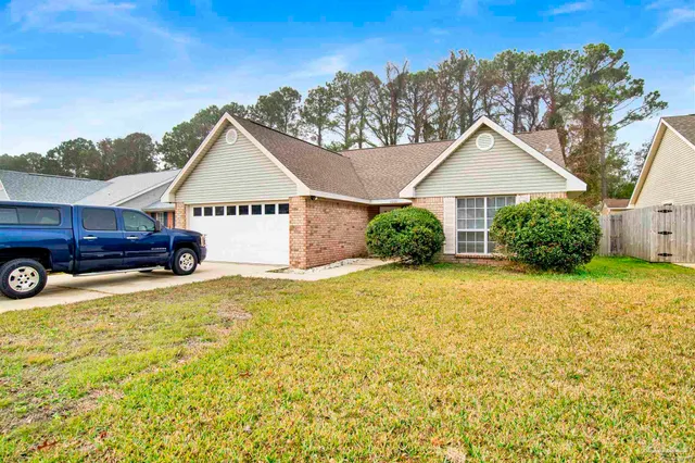 a view of a house with a garden and parking space