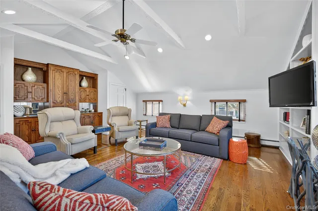 a living room with furniture a flat screen tv and a large window