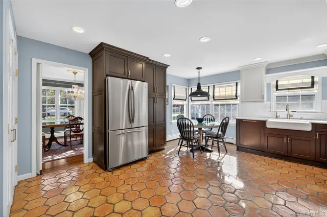 a kitchen with a refrigerator a dining table and chairs