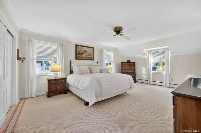 a bedroom with a large bed a chandelier and dresser