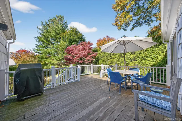 a patio with wooden floor a yard a table and chairs