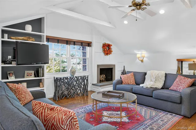 a living room with furniture a flat screen tv and a fireplace