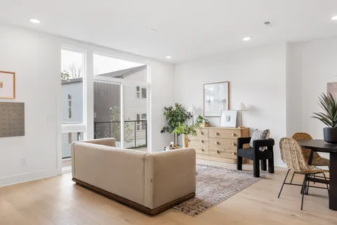 a living room with furniture potted plant and a large mirror