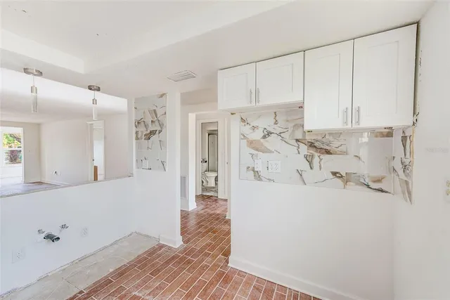a view of a kitchen with white cabinets
