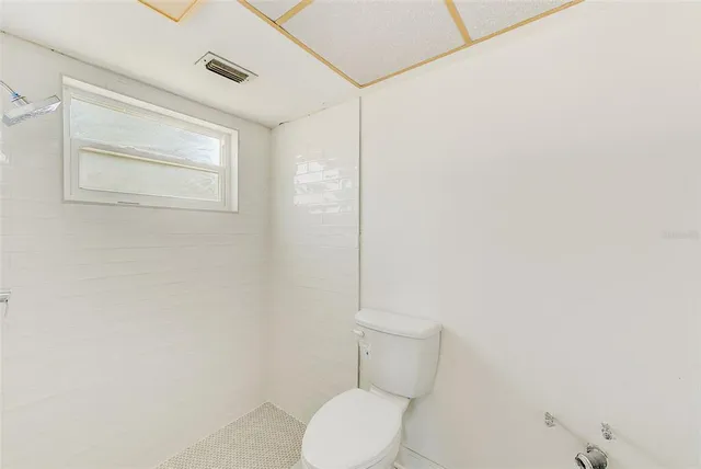 a white toilet sitting next to a shower