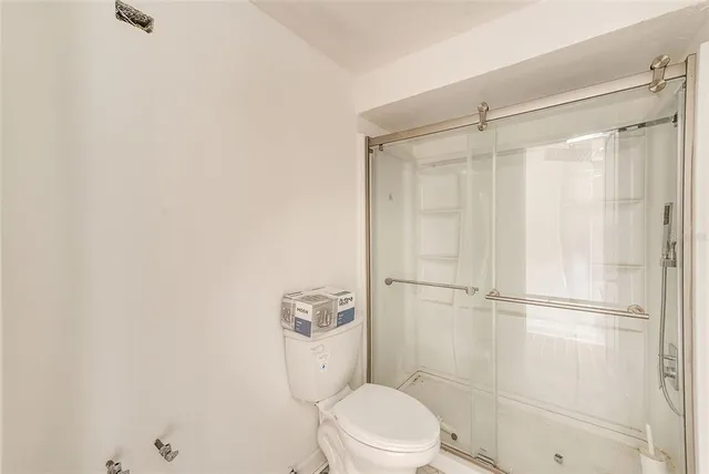 a white toilet sitting next to a shower