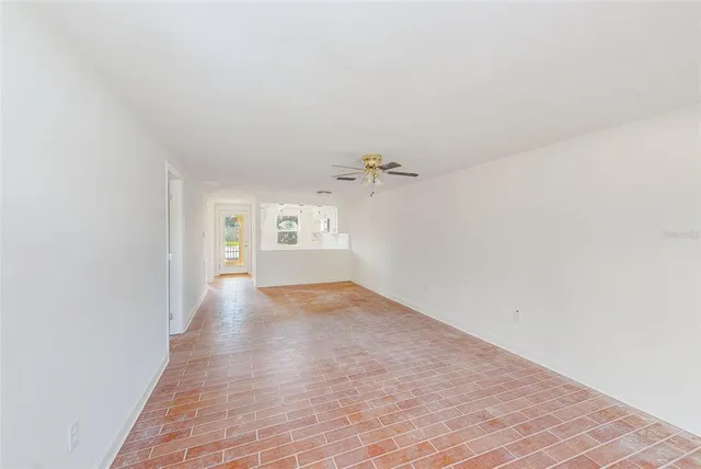 a view of a hallway with wooden floor and a bathroom