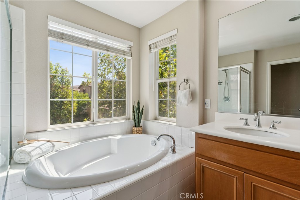 4155 Windspring Street Corona, CA 92883 - Photo 25 of 38 a bathroom with a tub a sink a mirror and a window