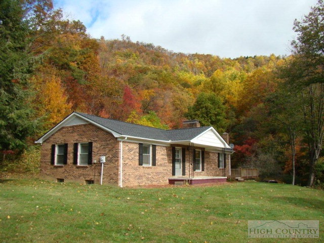 135 Ivy Ridge Road Deep Gap, NC 28618 - Photo 1 of 16 a front view of a house with a garden and trees