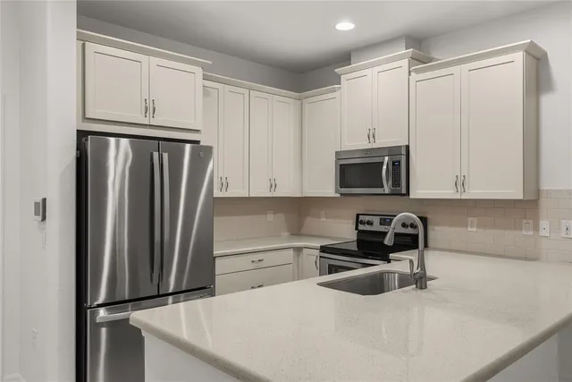 a kitchen with stainless steel appliances a refrigerator sink and cabinets