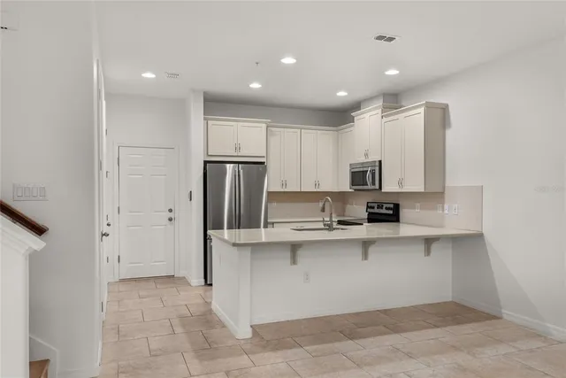 a kitchen with stainless steel appliances a sink and refrigerator