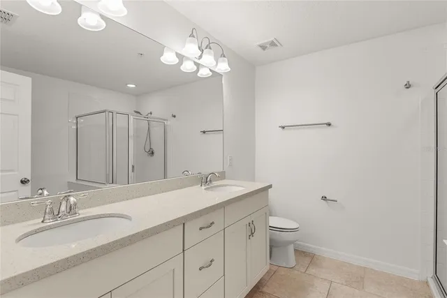 a bathroom with a granite countertop sink a toilet and a mirror