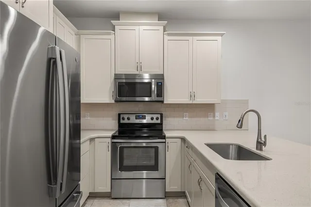 a kitchen with stainless steel appliances a stove microwave and sink