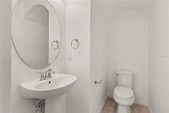 a bathroom with a sink toilet and a mirror
