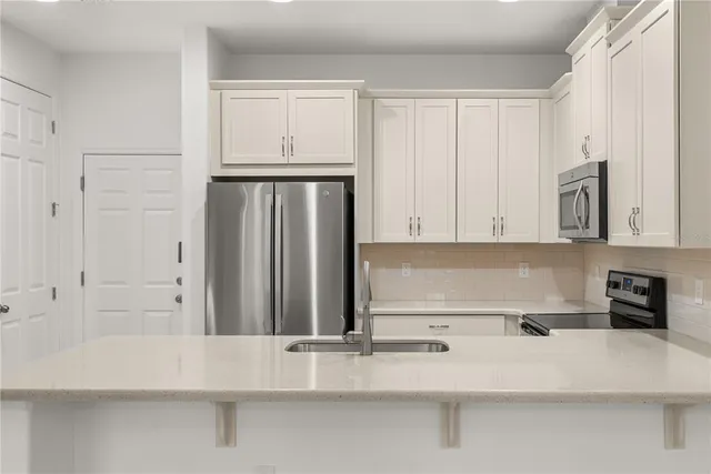 a kitchen with white cabinets and a refrigerator