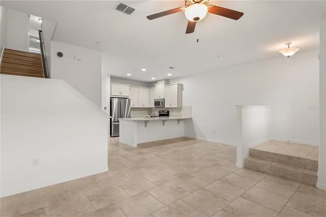 a view of kitchen with kitchen island white cabinets and refrigerator