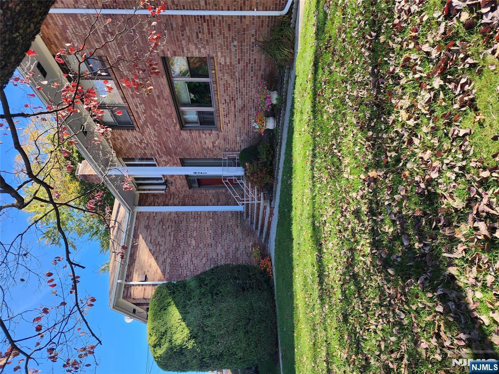 911-921 Teaneck Road, Unit B1 Teaneck, NJ 07666 - Photo 2 of 12 a view of a brick house with a yard