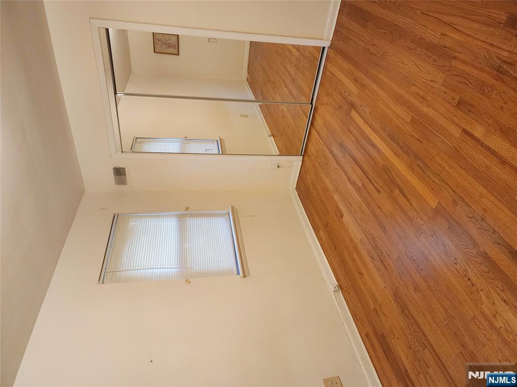 911-921 Teaneck Road, Unit B1 Teaneck, NJ 07666 - Photo 4 of 12 an empty room with wooden floor and windows